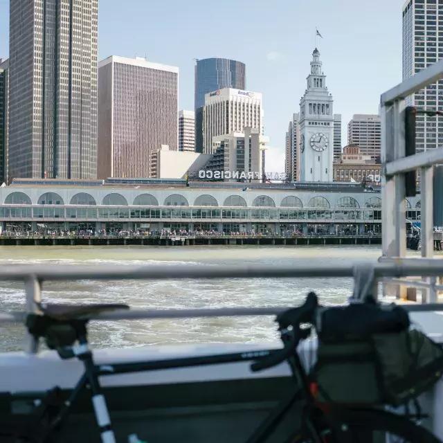脚踏车靠在栏杆上，背景是渡船大楼.